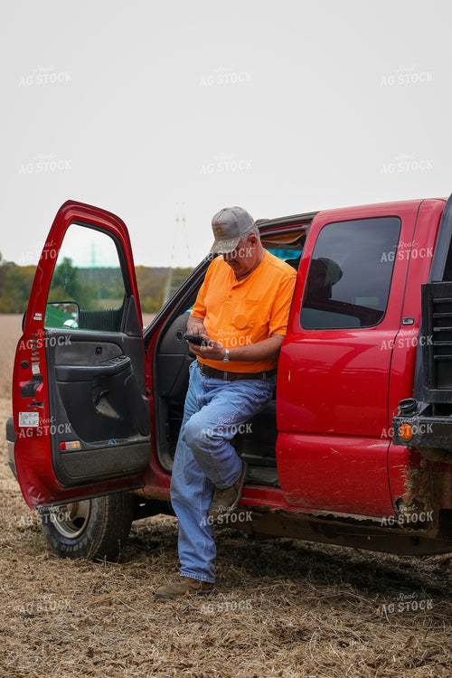Farmer Leaning on Truck with Phone 52569