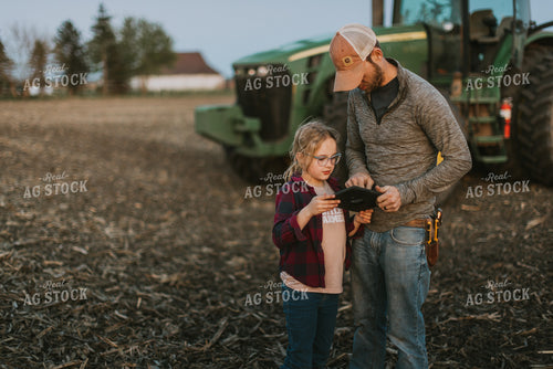 Farmer using Tablet in Field by Planter with Daughter 8260