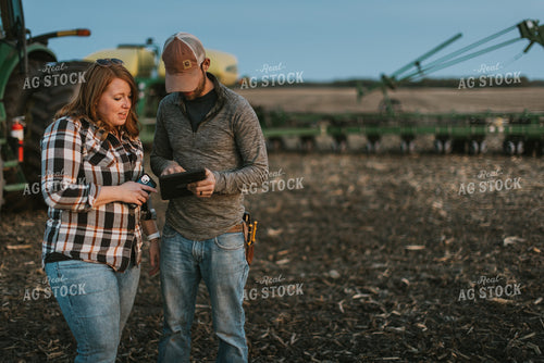 Farmers using Tablet in Field by Planter 8258
