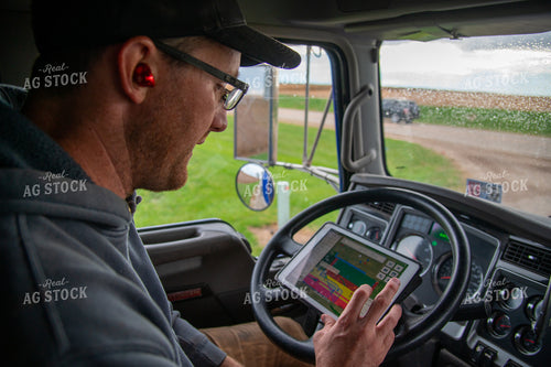Farmer Checking Tablet in Semi Cab 25558