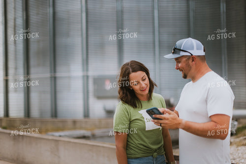 Farmer & Farm Wife Looking at Phone by Grain Bin 8768
