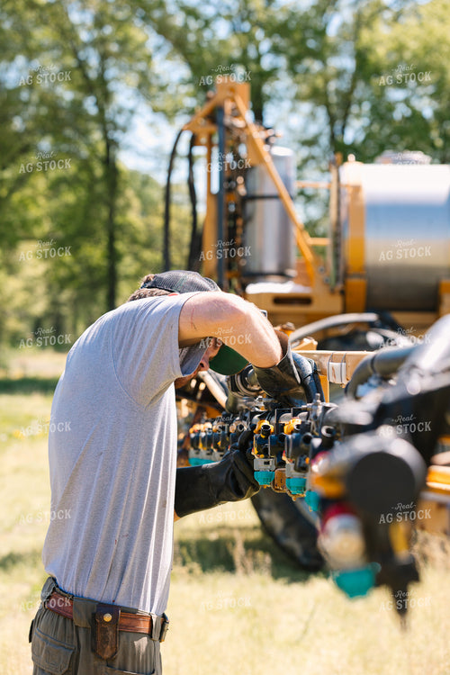Farmer Fixing Sprayer Nozzles 52721