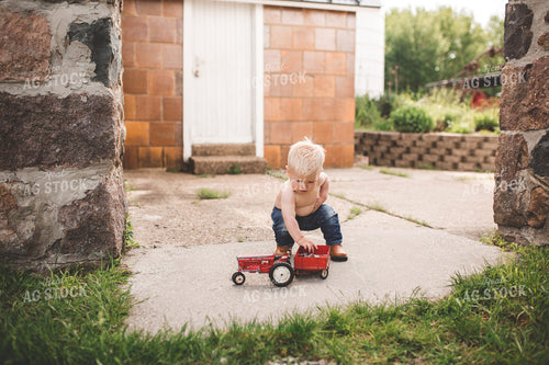 Farm Kid Playing with Toy Tractor 169021