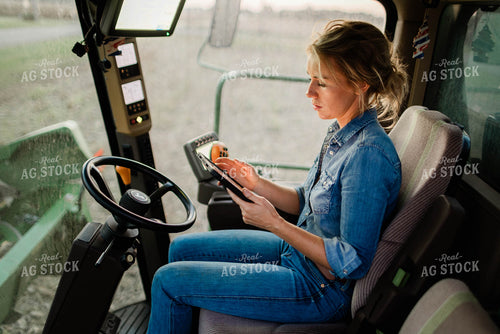 Female Farmer on Tablet in Combine Cab 8396