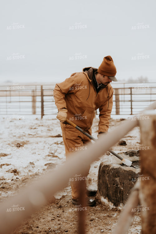 Rancher Breaking Up Water Trough 61235