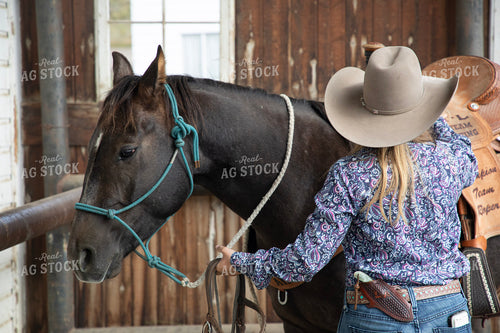 Female Rancher Tacking Horse 117108