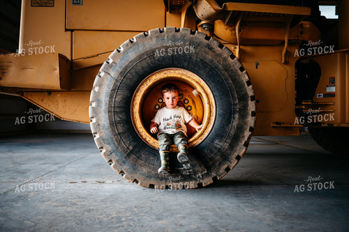 Farm Kid Sits in Tire Rim 56665