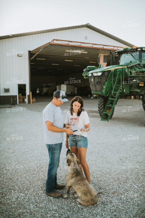 Farmer and Farm Wife Talking Outside Shop Looking at Phone 6239