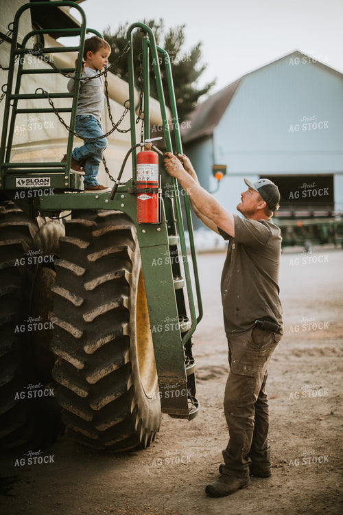 Farmer Working on Combine with Farm Kid 5130