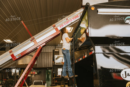 Woman Farmer Looks into Seed Tender Hopper 7588