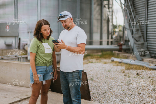 Farmer & Farm Wife Looking at Phone by Grain Bin 8762