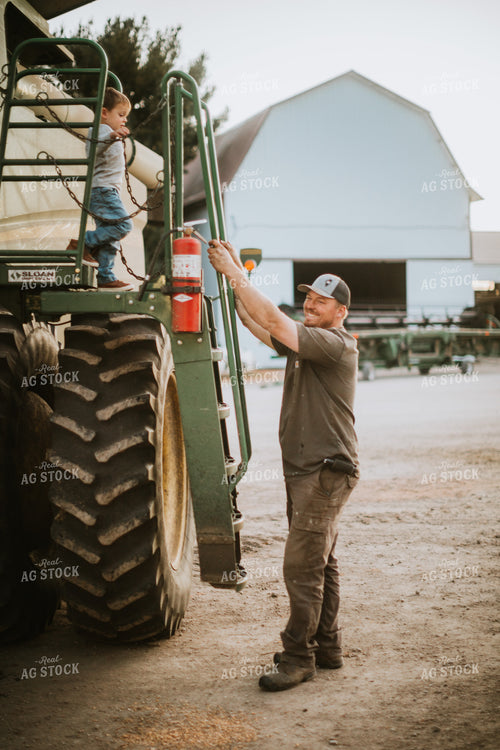 Farmer Working on Combine with Farm Kid 5131