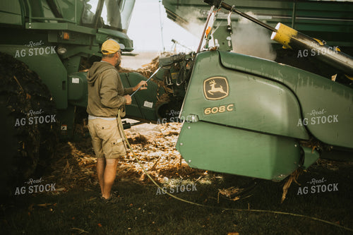 Farmer Cleaning Combine with Air Hose 4661
