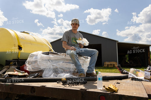 Farmer Eating Lunch on Seed Bag Pallet 52368