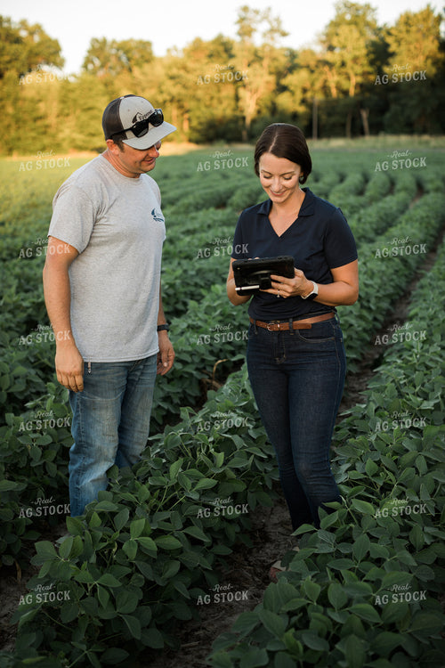 Agronomist and Farmer in Soybean Field Looking at Tablet 6103