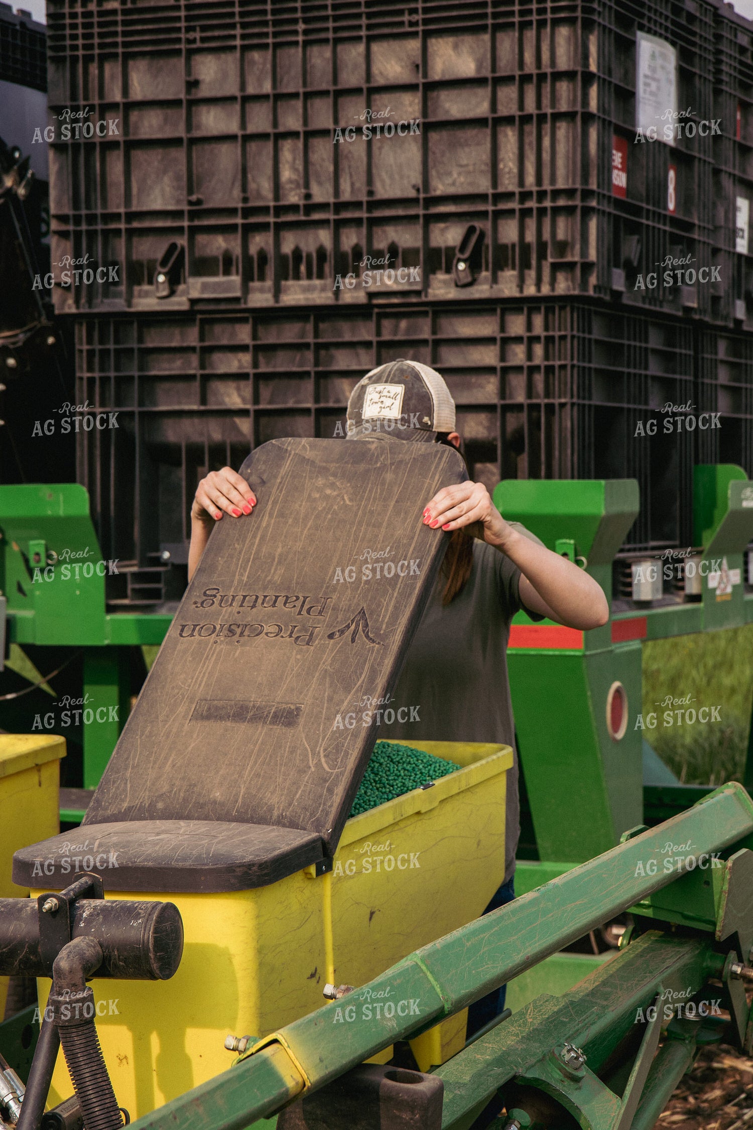 Female Farmer Loading Planter Boxes with Seed 67302