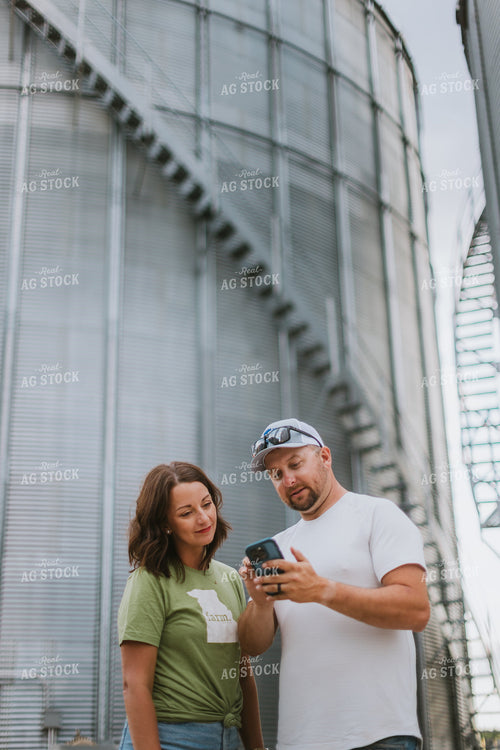 Farmer & Farm Wife Looking at Phone by Grain Bin 8772