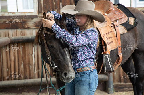 Female Rancher Tacking Horse 117111