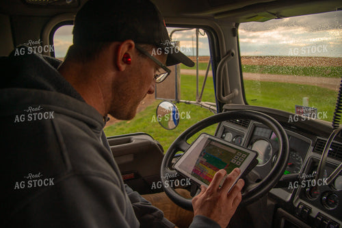 Farmer Checking Tablet in Semi Cab 25557