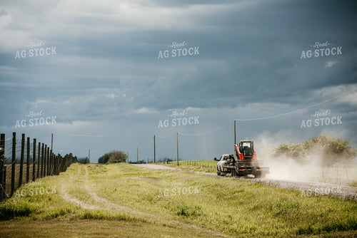 Truck and Trailer with Skidloader on Rural Road 64083