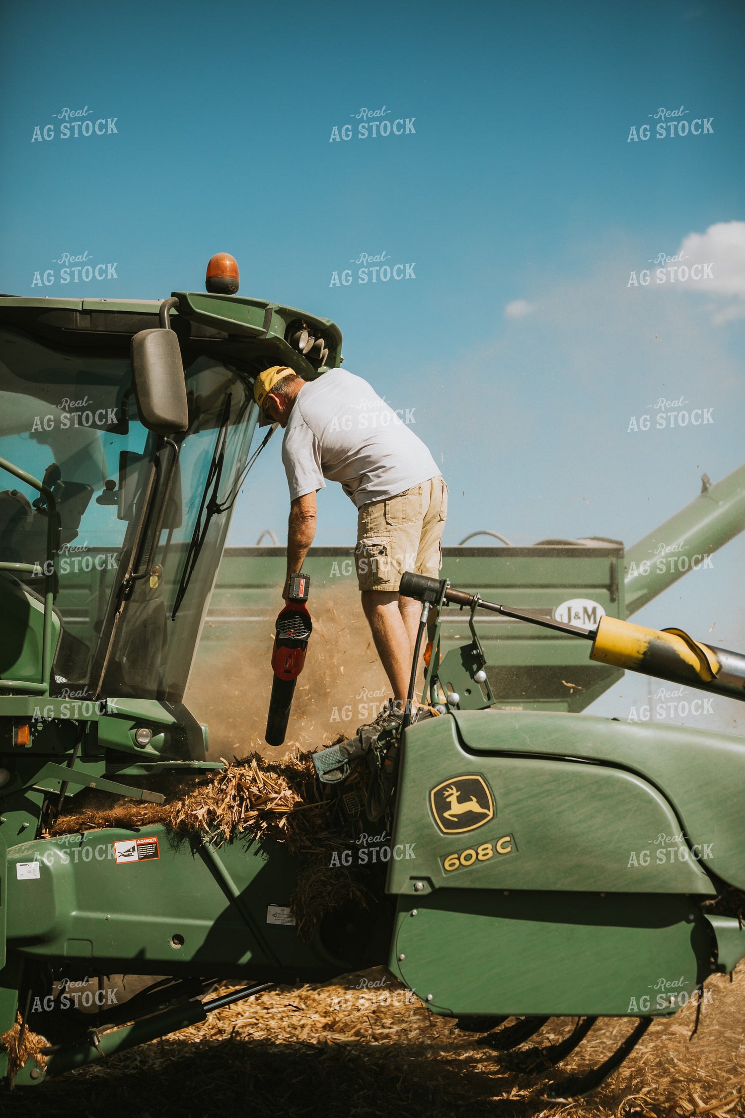 Farmer Cleaning Corn Stalks Off Combine Header 4724