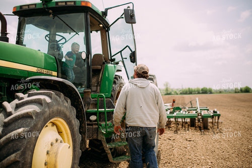 Farmer Helping Son Out of Tractor 169077