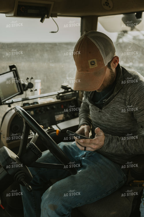 Farmer in Tractor Cab using Phone 8186