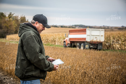 Farmer Looking at Tablet in Field 250079
