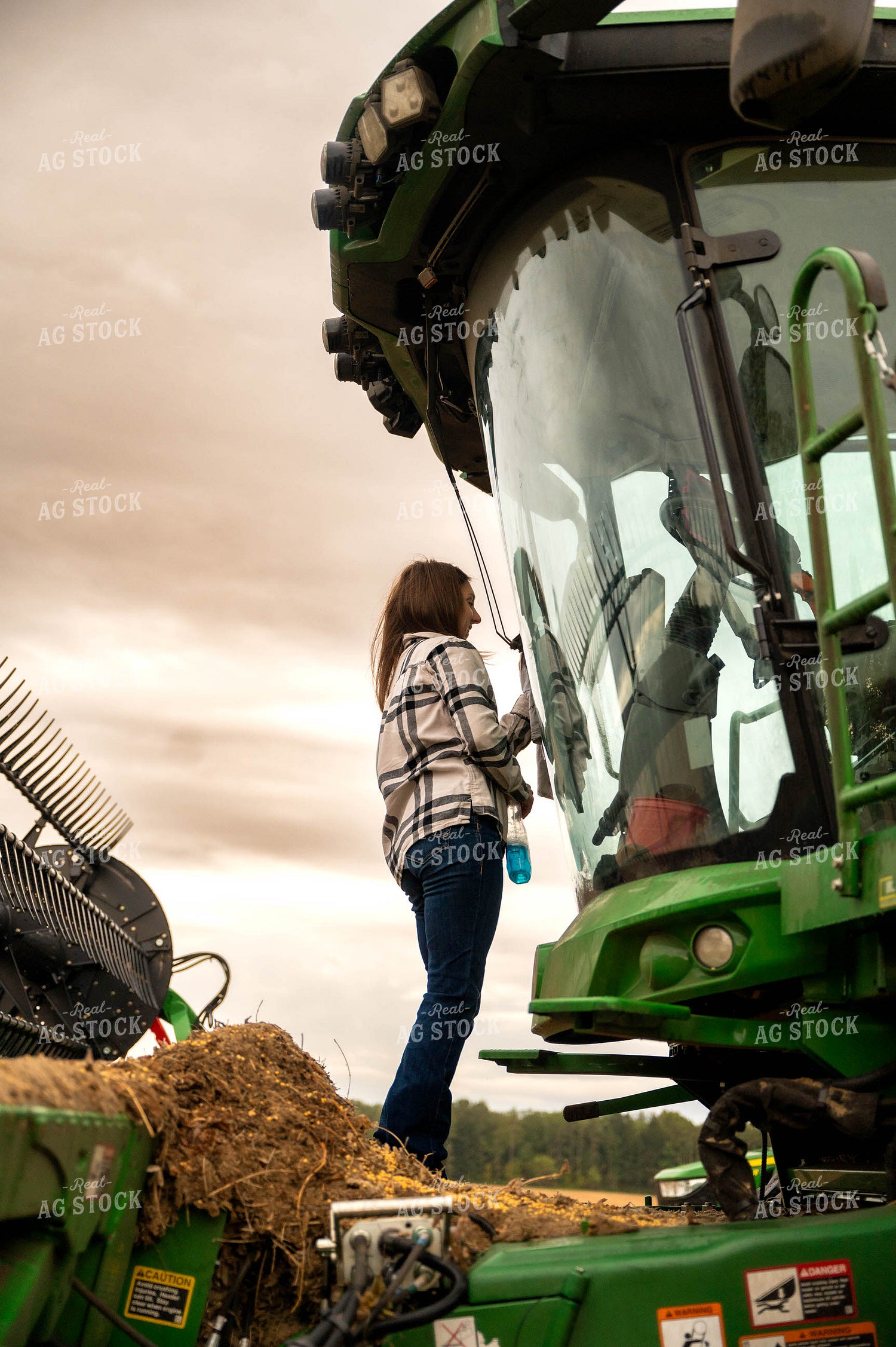 Female Farmer Cleaning Combine Windshield 115407