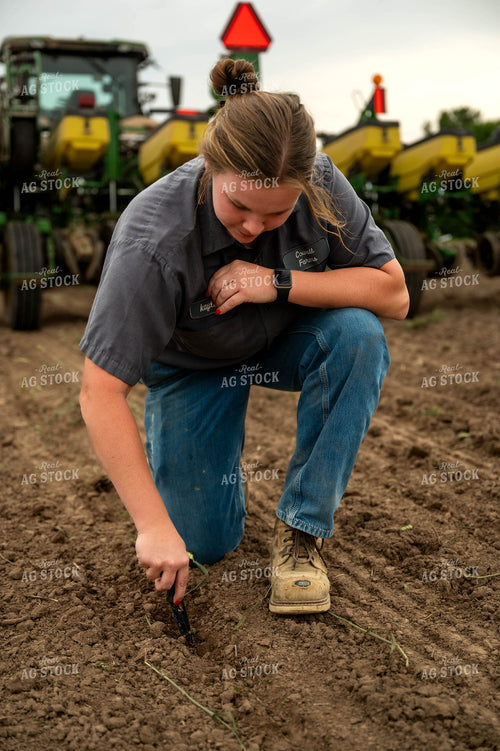 Female Farmer Checking Seed Depth Behind Planter 115697