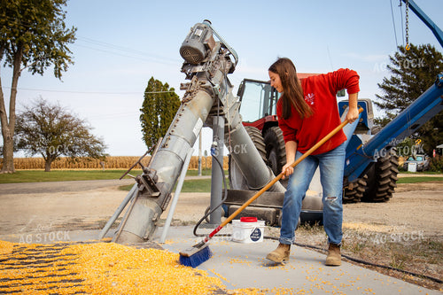 Female Farmer Sweeping Corn into Grain Pit 268103