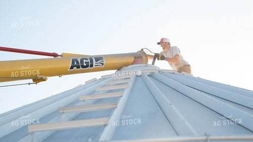 Farmer Greasing Auger on Top of Bin 26106