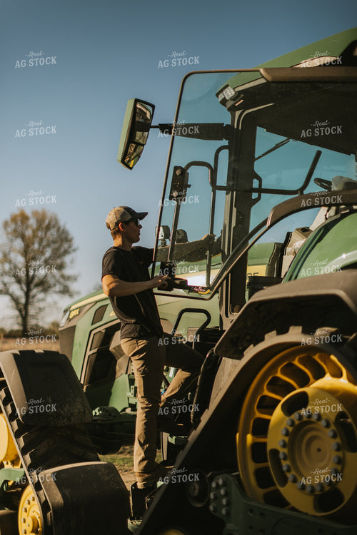 Young Farmer Climbs into Tractor Cab 7646