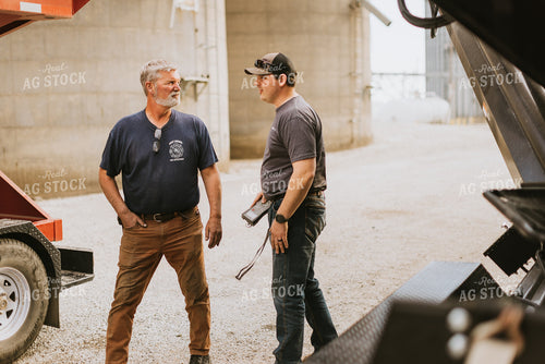 Farmers Talk in Front of Grain Bins 7598