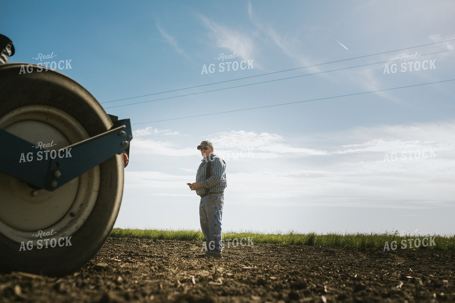 Farmer Looking at Phone in Field 4124