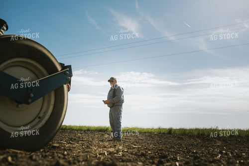 Farmer Looking at Phone in Field 4124