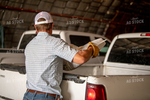 Rancher Lifting Bags of Mineral for Cattle 212045