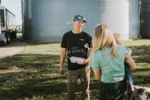 Young Farmer Greeting Family Delivering Field Meal 7636