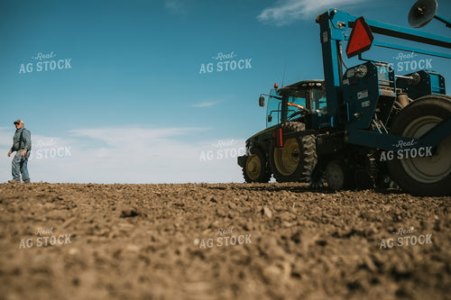 Farmer Climbing out of Tractor with Planter 4099