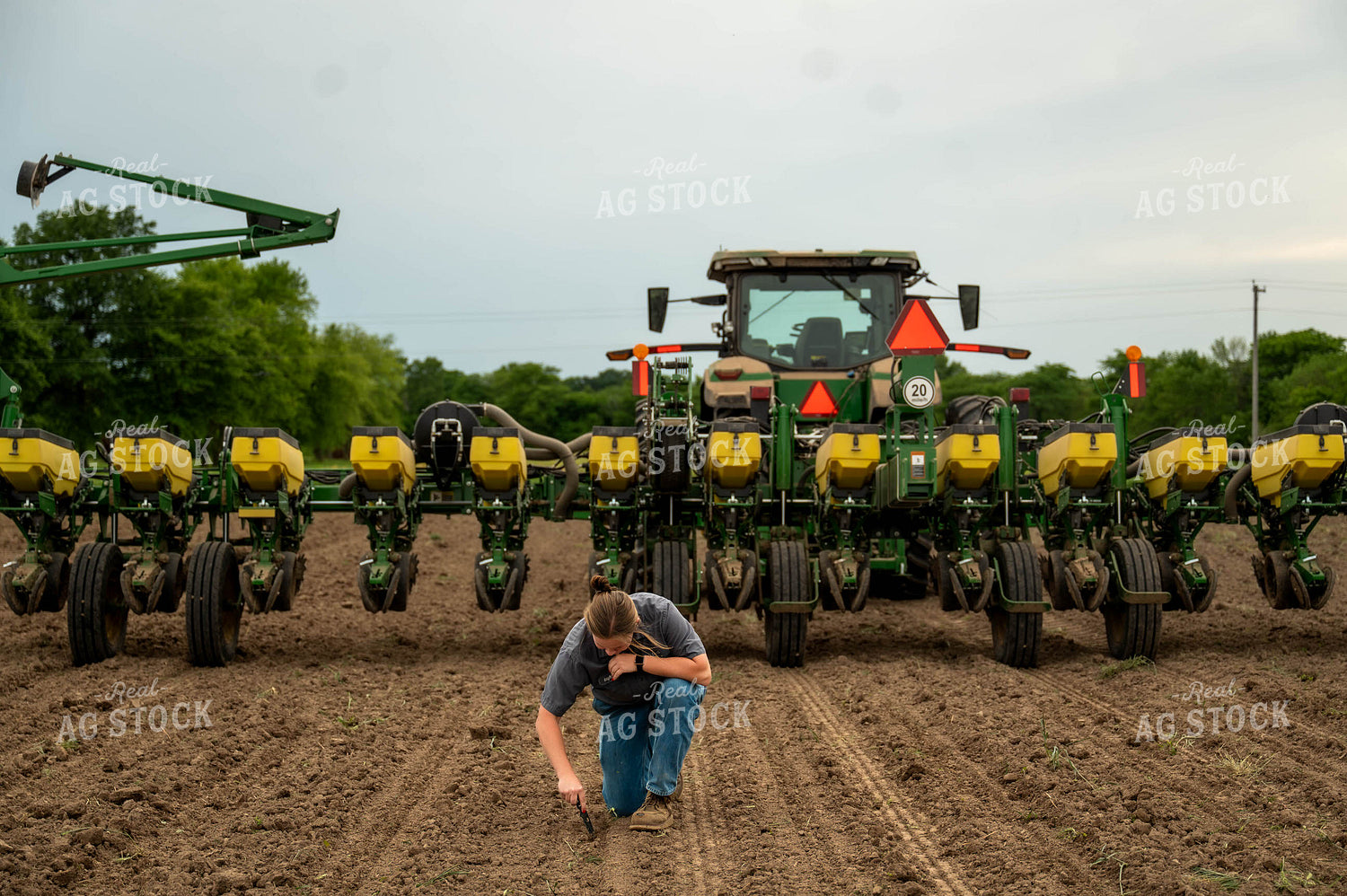 Female Farmer Checking Seed Depth Behind Planter 115695