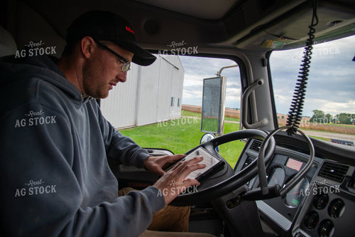 Farmer Checking Tablet in Semi Cab 25550