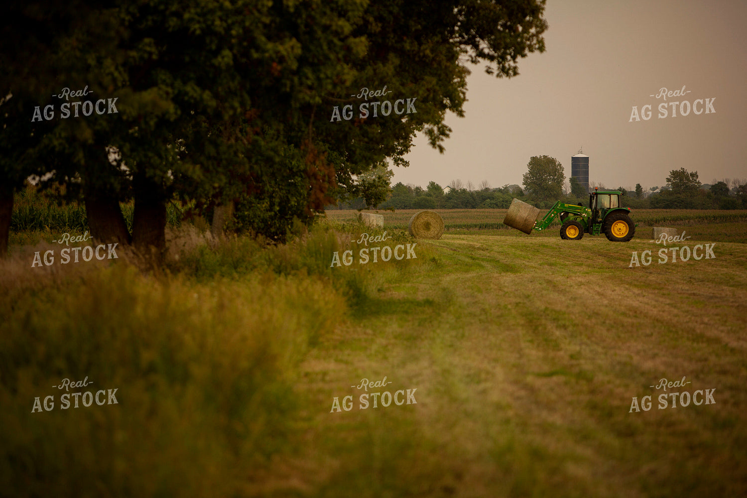 Tractor Lifting Round Hay Bale Side View 5519