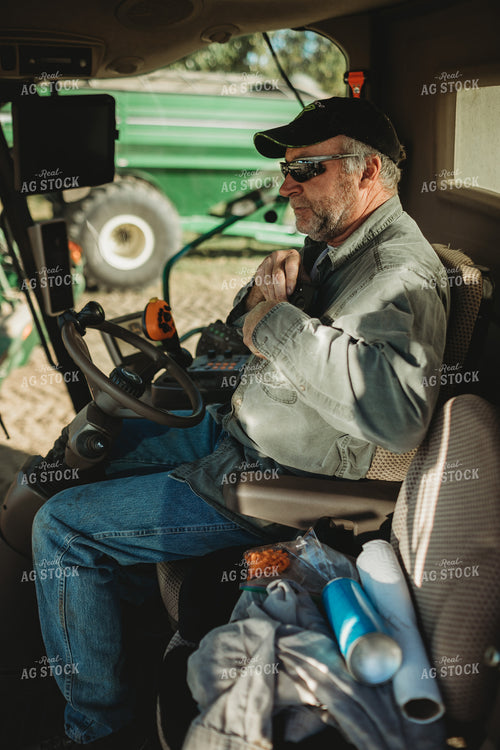 Farmer Looking at Phone in Combine Cab 5231