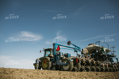 Farmer Climbing into Tractor with Planter 4131