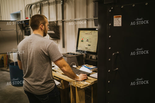Man Running Computer Program for Treating Seed 5293