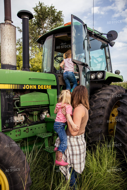 Female Farmer Getting into Tractor with Daugthers 67376