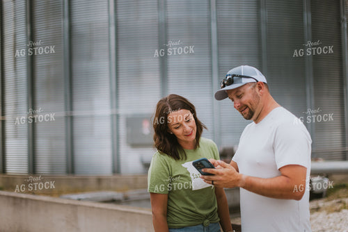 Farmer & Farm Wife Looking at Phone by Grain Bin 8769