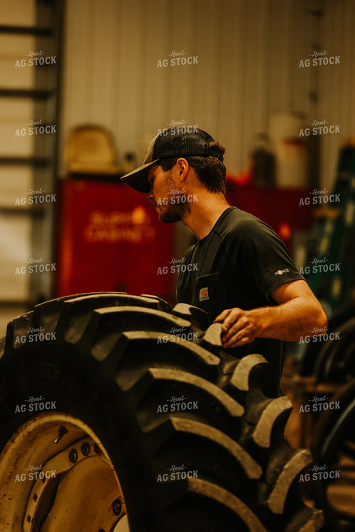 Farmer with Tire in Shed 52440