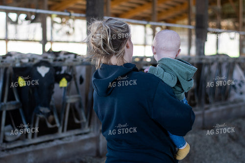 Female Farmer and Son with Holsteins in Barn 50497
