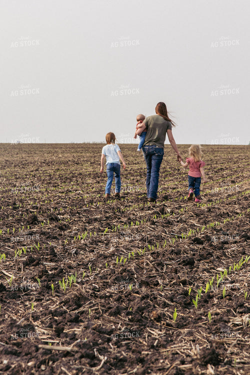 Female Farmer and Daughters Play in Emerging Corn Field 67289